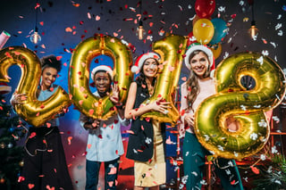 four people holding up numbers 2018 with confetti 