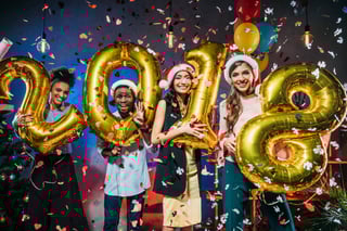four people holding up numbers 2018 with confetti four people holding up numbers 2018 with confetti