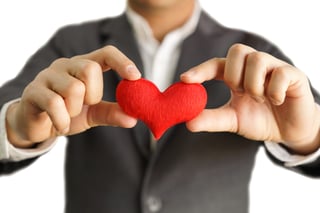 Man's hands holding small red stuffed heart Man's hands holding small red stuffed heart